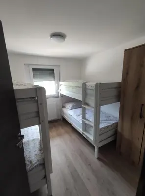 a room with two bunk beds and a window at Družinski apartmaji Judnič in Adlešiči