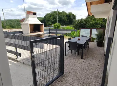 a patio with a table and a grill with a table and chairs at Družinski apartmaji Judnič in Adlešiči