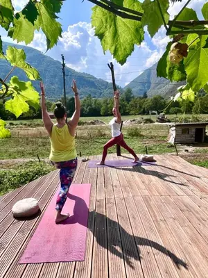 two women doing yoga on a wooden deck at Kamer Luna in Log Čezsoški