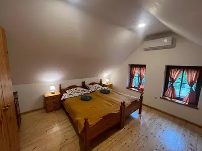 a bedroom with a large bed and two windows at Vila Anton in Dobrna
