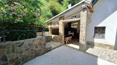a building with a stone wall and a patio at Vila Anton in Dobrna