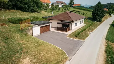 a house with a garage and a driveway at Holiday Home Kamence in Rogaška Slatina