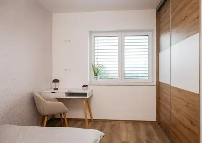 a bedroom with a bed and a desk and a window at Holiday Home Kamence in Rogaška Slatina