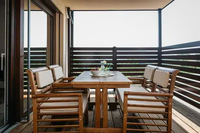 a dining room with a table and chairs on a balcony at Holiday Home Kamence in Rogaška Slatina