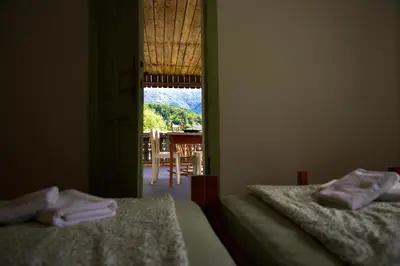 two beds in a room with a view of a table at Vintage Lake House Bohinj in Bohinj