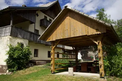 a large wooden pavilion in front of a house at Vintage Lake House Bohinj in Bohinj