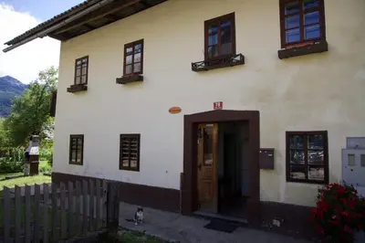 a building with a door and a dog standing outside at Vintage Lake House Bohinj in Bohinj