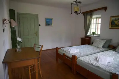 a bedroom with two beds and a table and a door at Vintage Lake House Bohinj in Bohinj