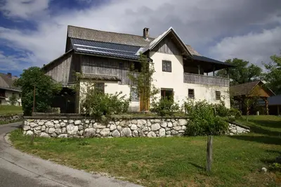 an old house with a stone wall at Vintage Lake House Bohinj in Bohinj