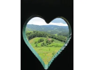 a heart shaped window with a view of a valley at Holiday home with 2 bedrooms in Zgornja Kungota