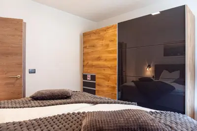 a bedroom with two beds and a large mirror at Vila Hrastnica in Škofja Loka