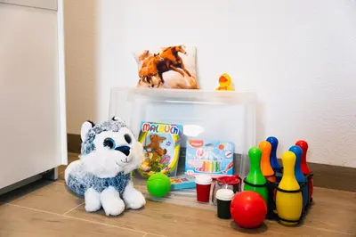 a stuffed animal and toys on the floor next to a box of toys at Vila Hrastnica in Škofja Loka