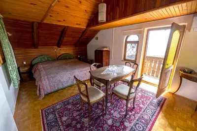 a bedroom with a bed and a table and chairs at Vineyard cottage Rustika in Novo Mesto