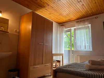 a bedroom with a large wooden cabinet and a bed at Sobe Cvetek in Bohinj