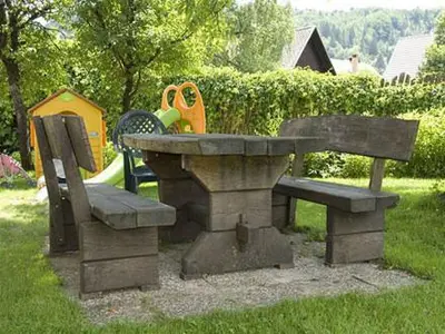 a picnic table and two benches in a park at Sobe Cvetek in Bohinj
