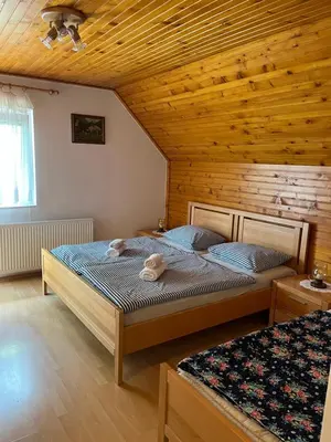 a bedroom with two beds and a wooden ceiling at Sobe Cvetek in Bohinj