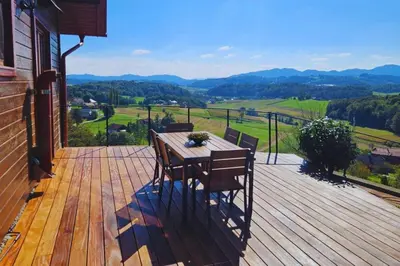 a wooden deck with a table and chairs on it at Brioni Hills - Premium Escape in Šmarje pri Jelšah