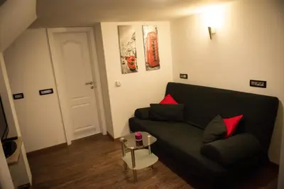 a living room with a black couch and red pillows at Apartment Arpa in Ljubljana