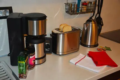 a counter with a coffee maker and a bread in a container at Apartment Arpa in Ljubljana