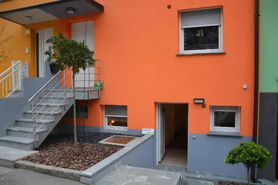 an orange building with a staircase in front of it at Apartment Arpa in Ljubljana