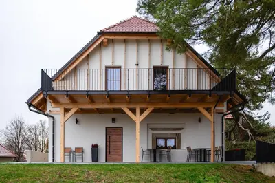 a house with a balcony on top of it at Vineyard Escape Herbersteinova klet in Juršinci