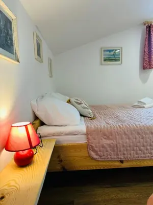 a bedroom with a bed and a lamp on a table at Stara Žaga in Bled
