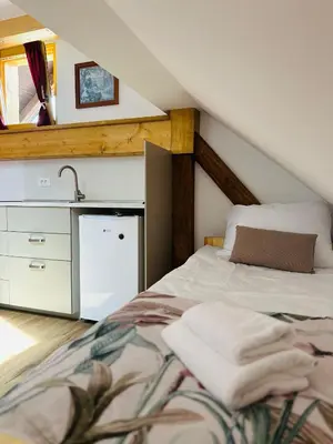 a attic bedroom with a bed and a sink at Stara Žaga in Bled