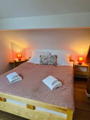 a bedroom with a large bed with two towels on it at Stara Žaga in Bled
