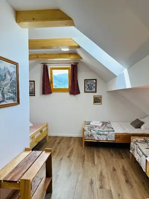 a room with two beds and a table at Stara Žaga in Bled