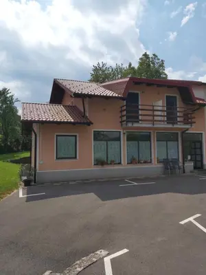 a house with a balcony and a parking lot at Rooms Zagon in Postojna