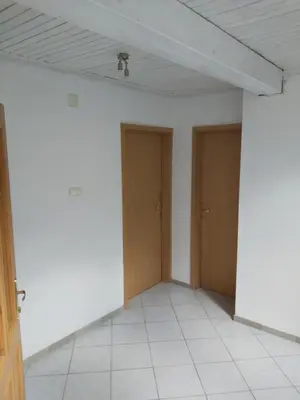 an empty room with two doors and a tile floor at Rooms Zagon in Postojna