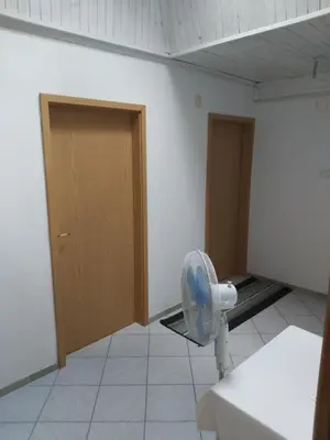 a room with a fan in a room with doors at Rooms Zagon in Postojna