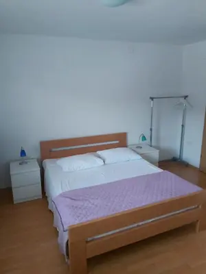 a bedroom with a bed and two night stands at Rooms Zagon in Postojna