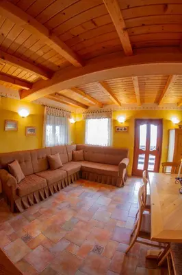 a living room with couches and a wooden ceiling at Zidanica Krošelj in Raka