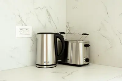 two coffee machines sitting on a counter next to a lightswitch at Sunny Green Escape in Lesce