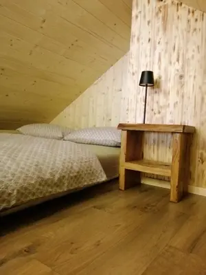 a bedroom with a bed and a table with a lamp at Hiša pod Rogatcem - studio in Luče
