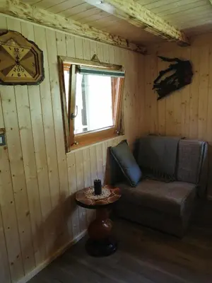 a room with a couch and a table and a clock at Hiša pod Rogatcem - studio in Luče
