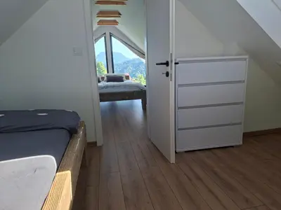 a bedroom with a bed and a door with a window at En hribček in Ptujska Gora