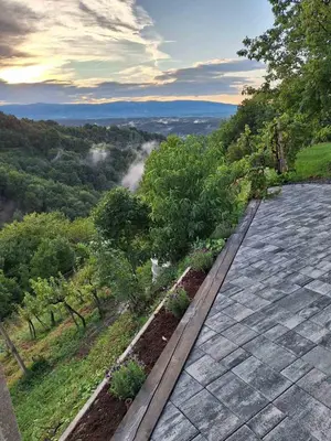 a stone patio with a view of a valley at En hribček in Ptujska Gora