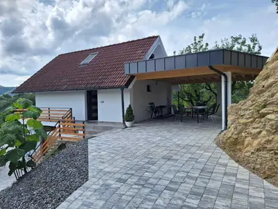 a house with a roof that has a patio at En hribček in Ptujska Gora