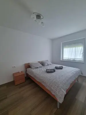 a white bedroom with a bed and a window at Vipava Valley Stay - Apartment Miki - With Patio, Parking & Pets OK in Ajdovščina