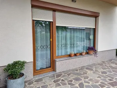 a window with potted plants on a building at Vipava Valley Stay - Apartment Miki - With Patio, Parking & Pets OK in Ajdovščina