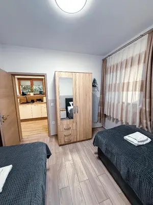 a bedroom with two beds and a large mirror at L Apartment II in Maribor