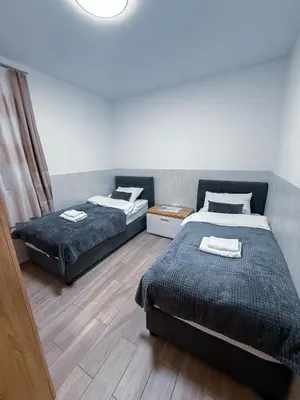 two beds in a small room with at L Apartment II in Maribor