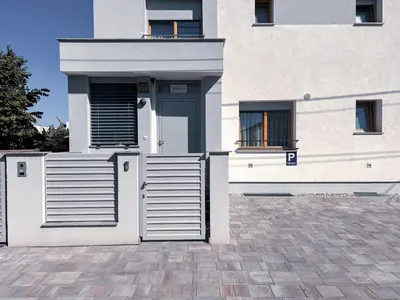 a white house with a gate in front of it at L Apartment II in Maribor