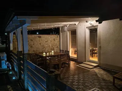 a dining room with a table and chairs on a balcony at Hiška Maša in Čatež ob Savi
