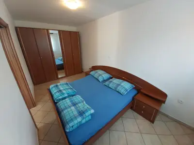 a small bedroom with a blue bed in a room at Apartments Petrin in Tolmin