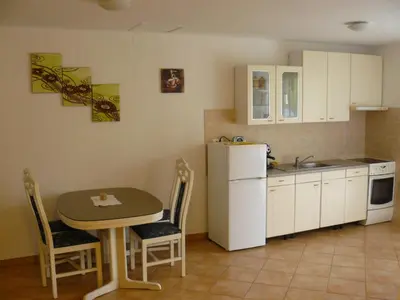 a small kitchen with a table and a refrigerator at Apartments Petrin in Tolmin