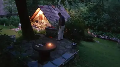 a man standing in front of a grill in a yard at Chalet Iskaretreat in Ig