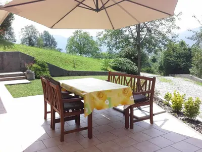 a table and chairs with an umbrella on a patio at Apartment Zadraga in Tolmin